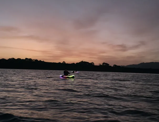 Kayak con luces bajo un cielo rosa al amanecer