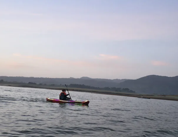 Persona remando en kayak durante las primeras horas de la mañana