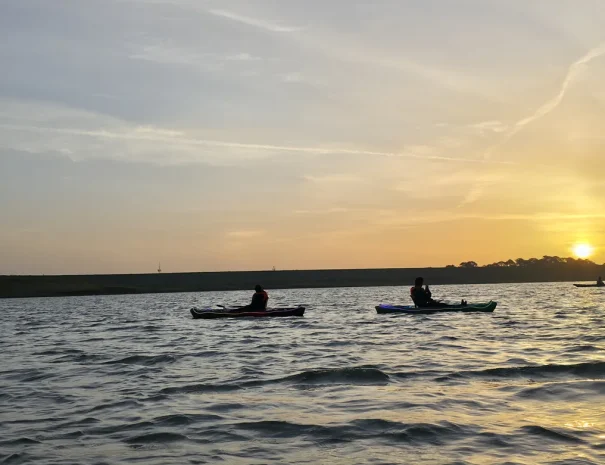 Dos kayaks frente al sol dorado del amanecer
